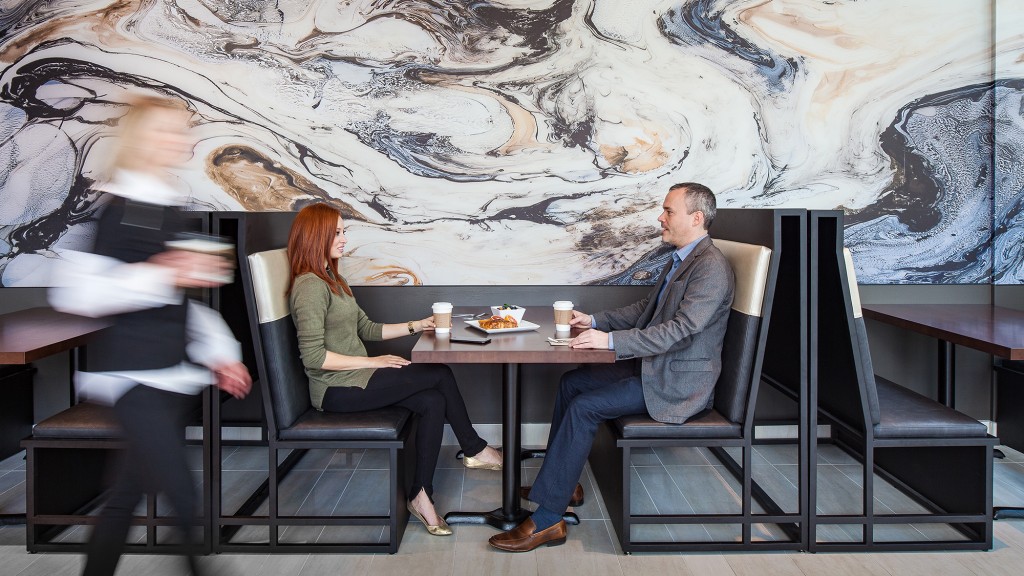A man and woman sitting at a table with drinks.